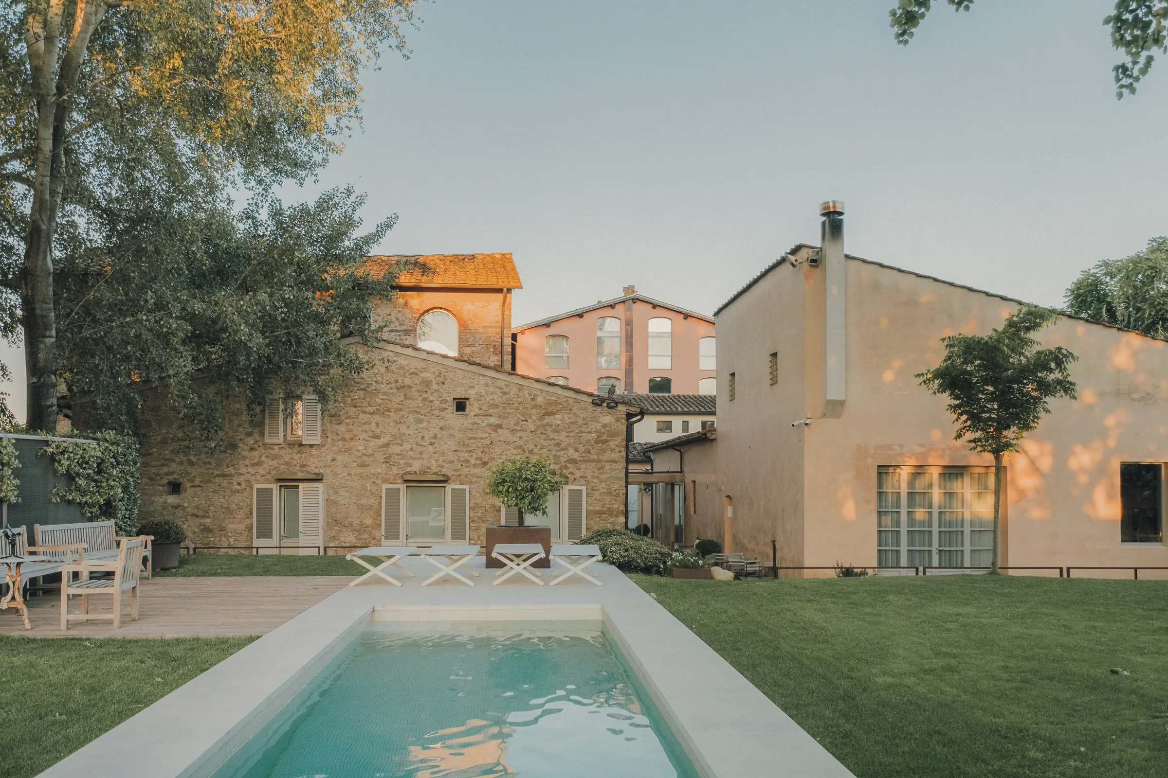Outdoor hospitality photography at Riva Lofts Florence featuring a contemporary garden restaurant, pool reflections, cocktails, natural light, and relaxed boutique hotel atmosphere in Florence, Italy.