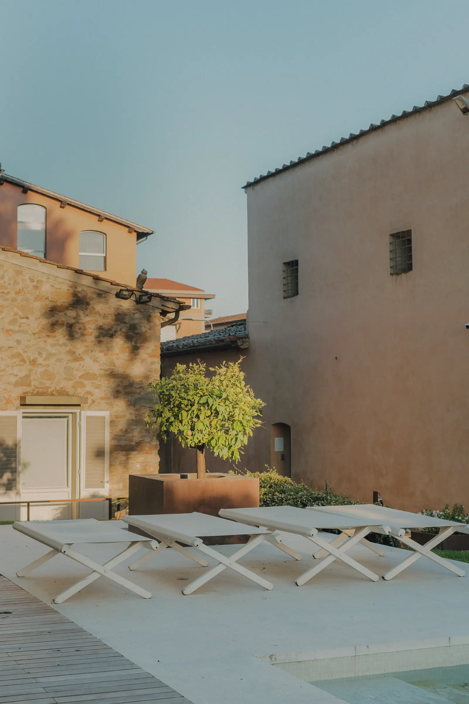 Outdoor hospitality photography at Riva Lofts Florence featuring a contemporary garden restaurant, pool reflections, cocktails, natural light, and relaxed boutique hotel atmosphere in Florence, Italy.
