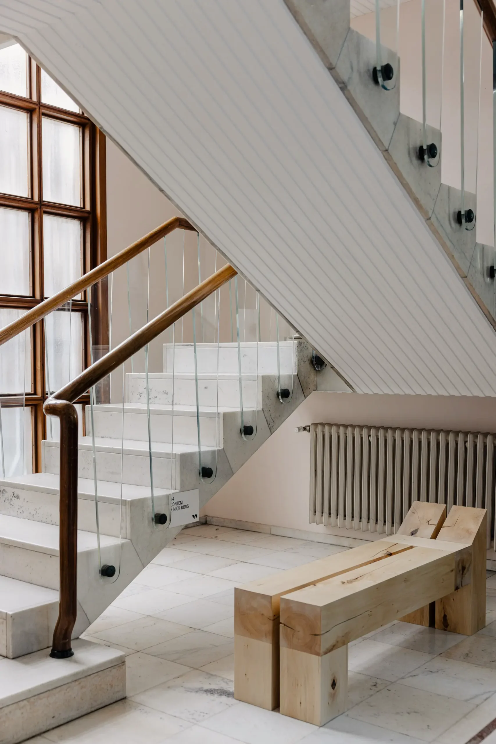 Atmospheric contemporary design installation at Alcova Milan with experimental interiors, sculptural objects, raw textures, and dramatic architectural light.