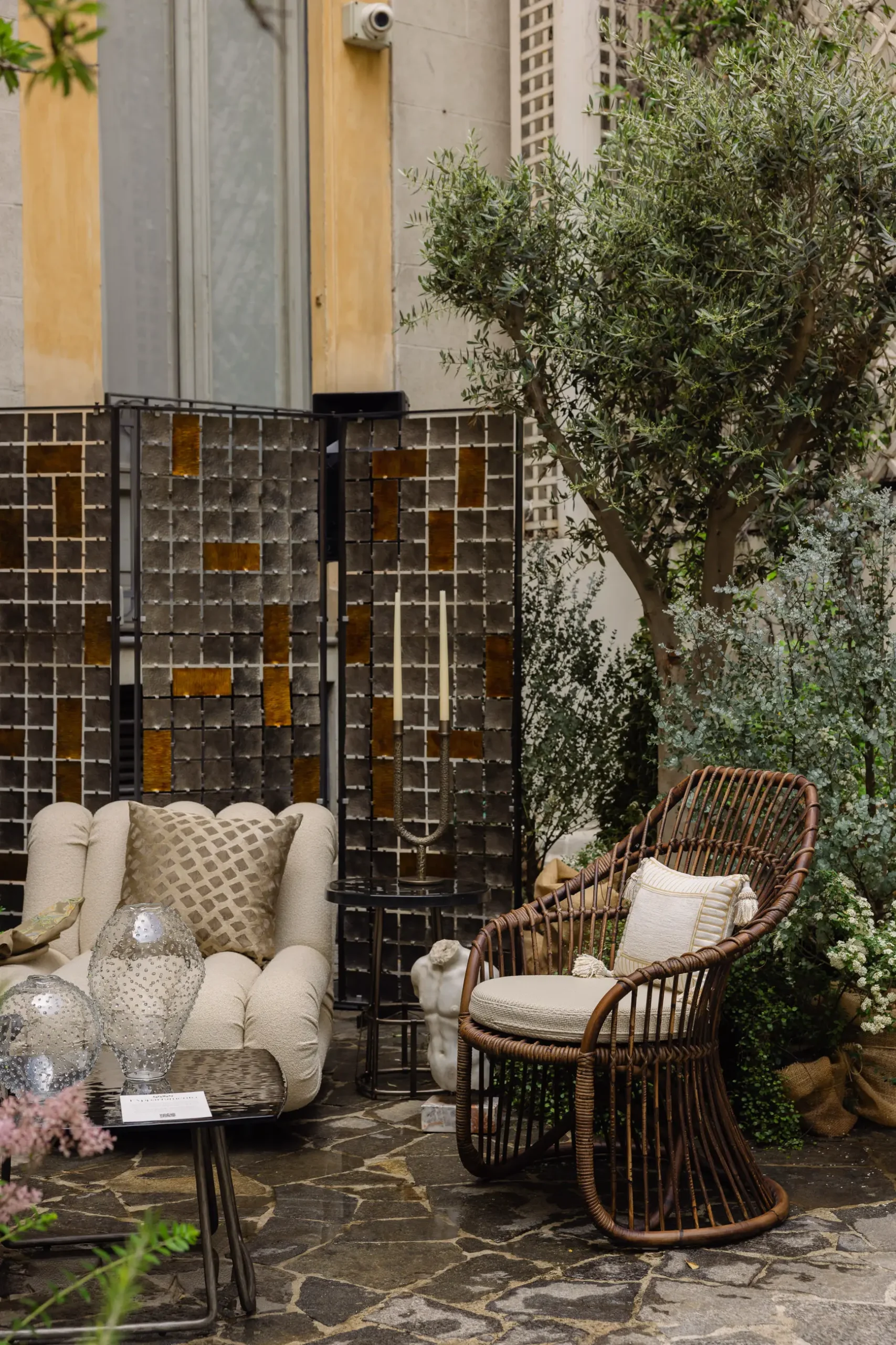 Contemporary interior installation by Artemest in Milan featuring collectible Italian design, sculptural furniture, layered textures, warm tones, and atmospheric natural light.