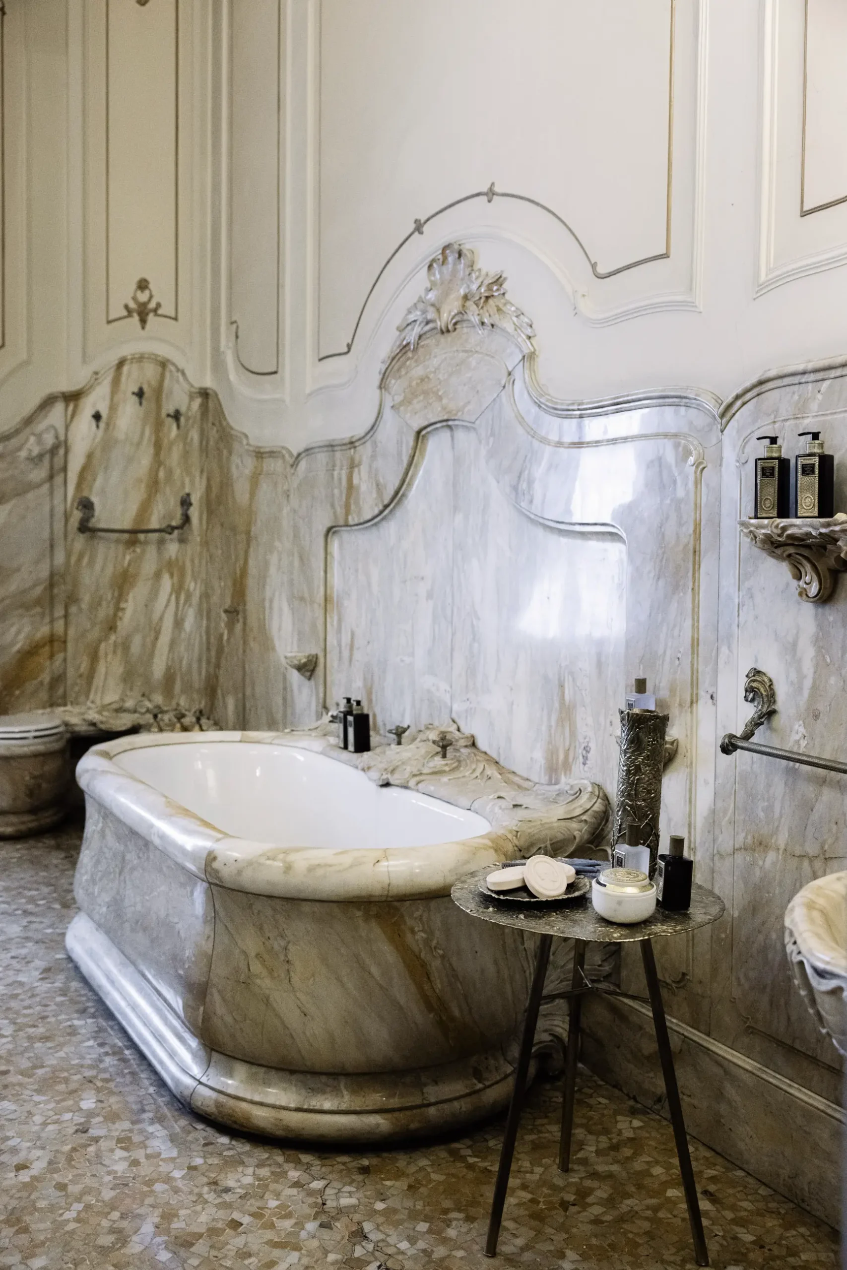 Contemporary interior installation by Artemest in Milan featuring collectible Italian design, sculptural furniture, layered textures, warm tones, and atmospheric natural light.